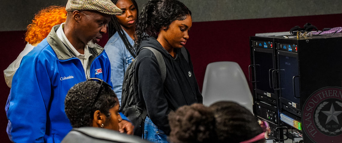 Students learning hands-on with professor in the studio